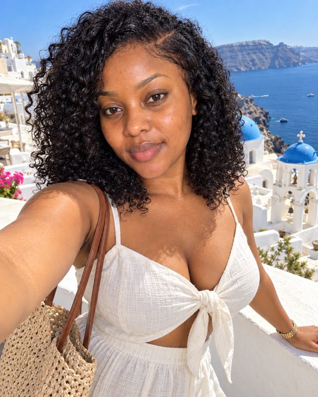 AI photo of the same woman in Santorini